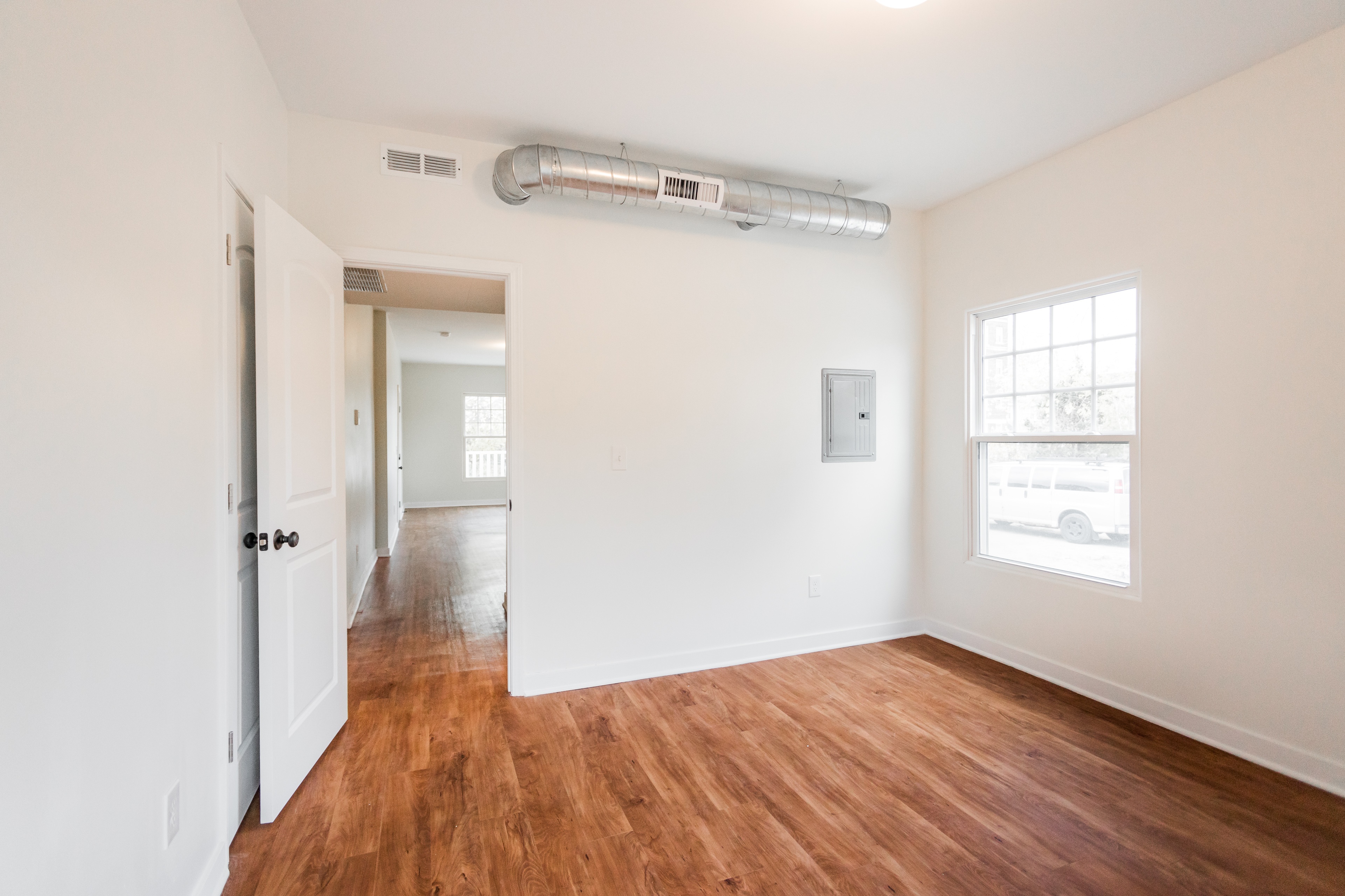 A room with a wooden floor and a window.